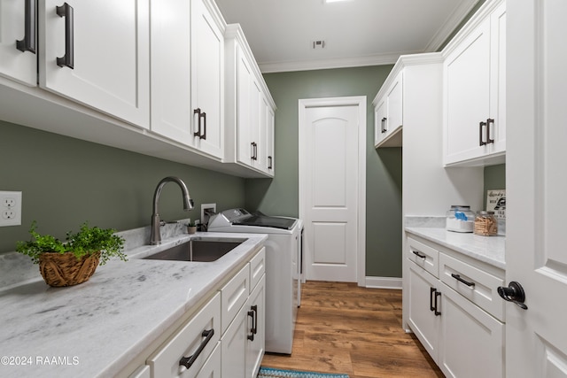 laundry area with washer and clothes dryer, cabinets, sink, crown molding, and dark hardwood / wood-style flooring