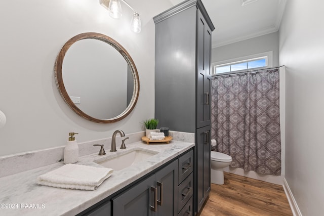 bathroom featuring wood-type flooring, vanity, toilet, and crown molding