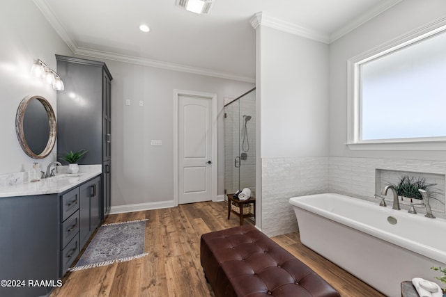 bathroom featuring wood-type flooring, vanity, shower with separate bathtub, and crown molding