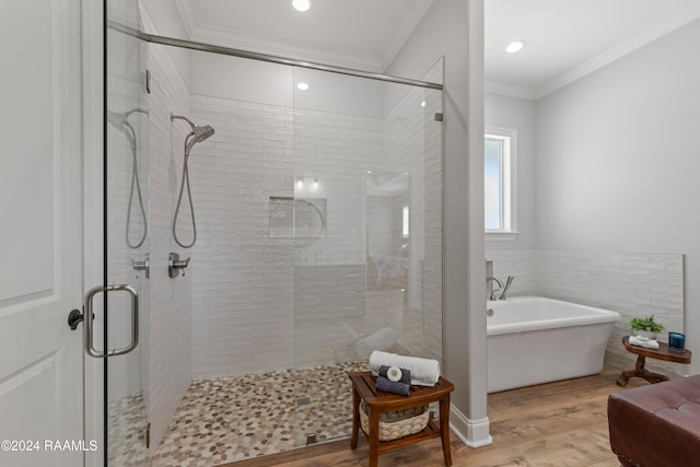 bathroom with wood-type flooring, shower with separate bathtub, and ornamental molding