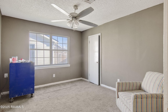 living area featuring a textured ceiling, light colored carpet, and ceiling fan