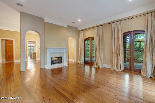 106 Kings Walk, Lafayette, LA 70503 - unfurnished living room with plenty of natural light, ornamental molding, french doors, hardwood / wood-style flooring, and arched walkways