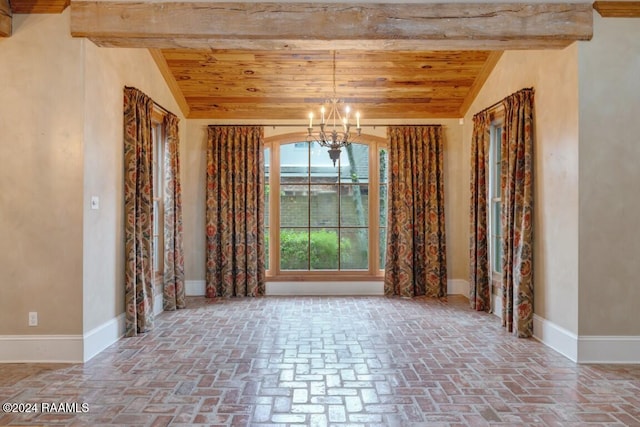 empty room with an inviting chandelier and vaulted ceiling with beams