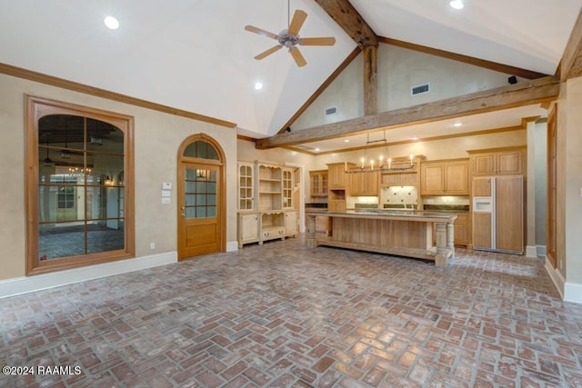 kitchen featuring a kitchen island, paneled fridge, high vaulted ceiling, hanging light fixtures, and ceiling fan with notable chandelier