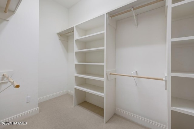 walk in closet featuring light carpet