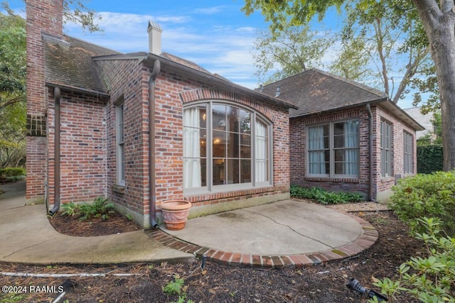 106 Kings Walk, Lafayette, LA 70503 - rear view of property featuring brick siding, a chimney, a patio, and roof with shingles