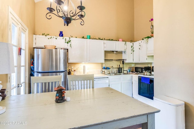 100 Teal Ln Unit 21, Lafayette, LA 70507 - kitchen featuring white appliances, a sink, white cabinets, healthy amount of natural light, and a towering ceiling