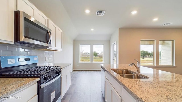 kitchen featuring white cabinets, sink, dark hardwood / wood-style floors, light stone countertops, and stainless steel appliances