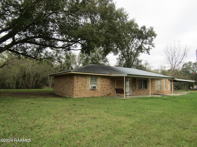 rear view of house featuring a yard and a carport