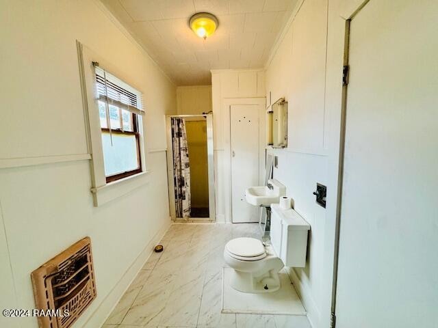 bathroom with a shower with shower curtain, toilet, crown molding, and sink