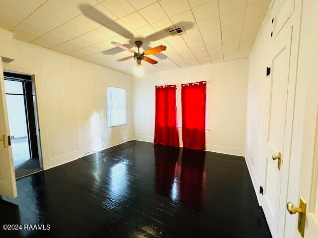 spare room featuring ceiling fan and dark wood-type flooring