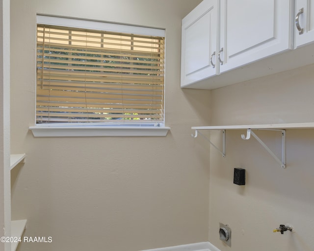 laundry room with hookup for an electric dryer, gas dryer hookup, and cabinets