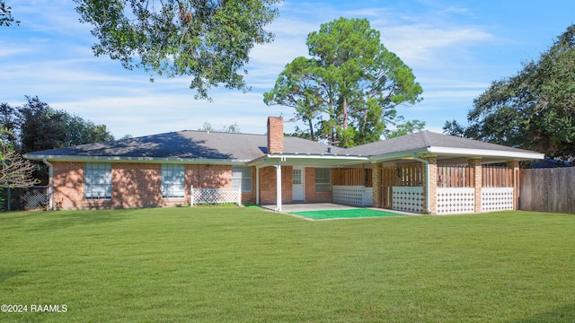 rear view of property featuring a patio area and a yard