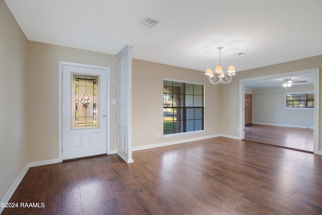 foyer featuring dark wood-type flooring, ceiling fan with notable chandelier, and plenty of natural light