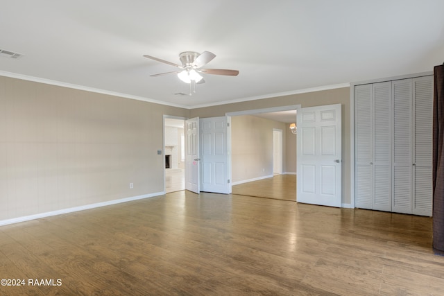 interior space with hardwood / wood-style flooring, ceiling fan, and crown molding