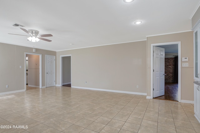 tiled empty room with ceiling fan and crown molding