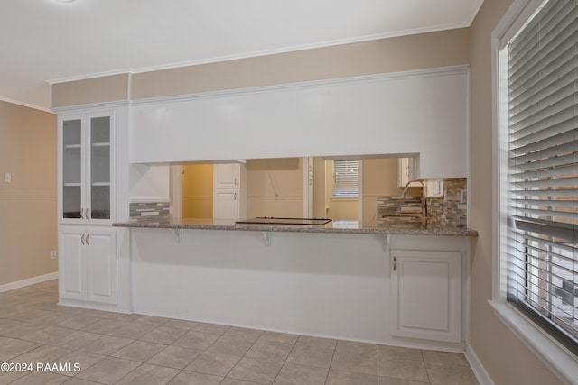 kitchen featuring ornamental molding, white cabinetry, and tasteful backsplash