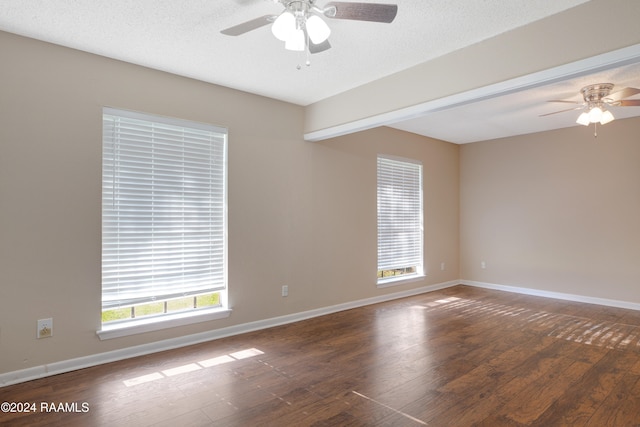 empty room with ceiling fan, dark hardwood / wood-style floors, and a textured ceiling