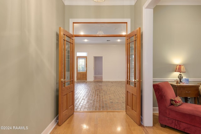 corridor featuring french doors, light hardwood / wood-style floors, and crown molding