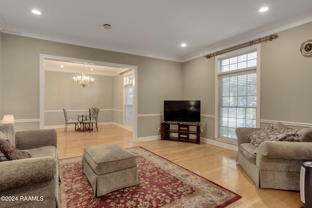 living room with hardwood / wood-style flooring, an inviting chandelier, and ornamental molding