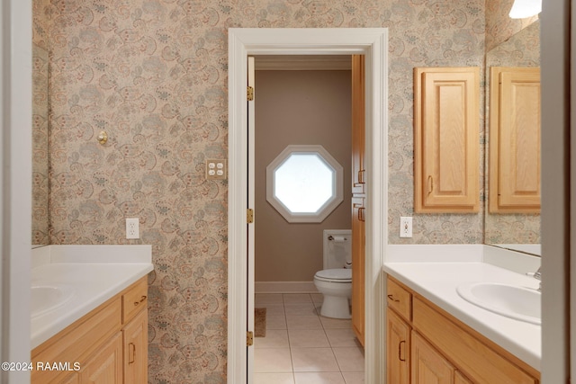 bathroom with toilet, vanity, and tile patterned flooring