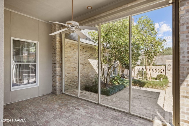 unfurnished sunroom featuring ceiling fan