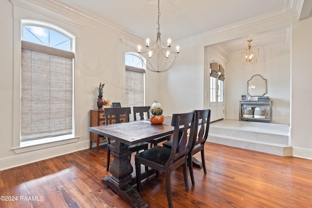 dining space featuring ornamental molding, hardwood / wood-style flooring, and a chandelier