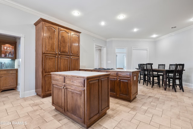 kitchen with crown molding and a kitchen island