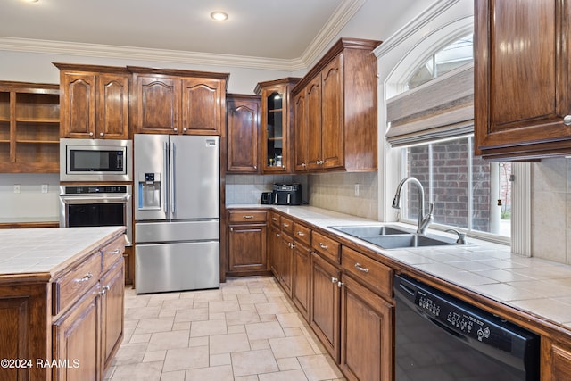 kitchen featuring tile counters, stainless steel appliances, sink, ornamental molding, and backsplash