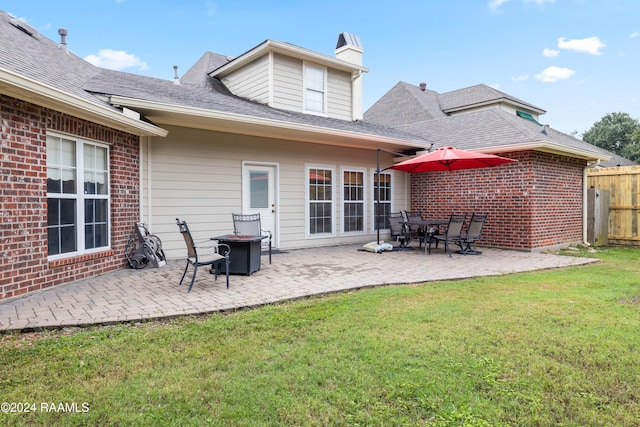 rear view of property featuring a yard and a patio area