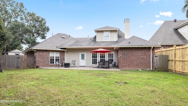 rear view of house with a lawn and a patio area