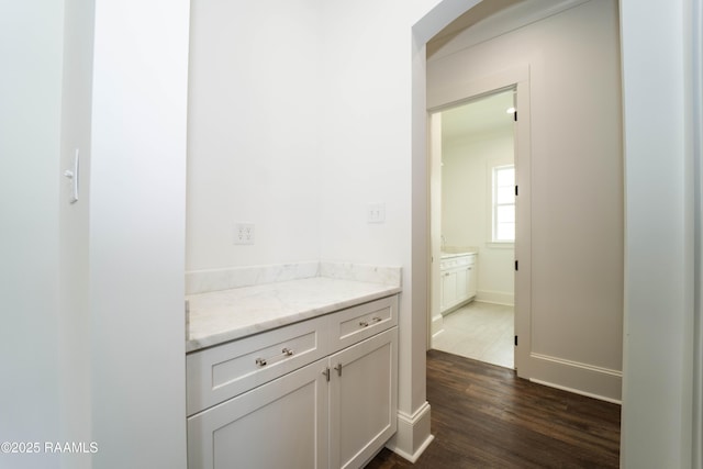 interior space with baseboards, wood finished floors, and vanity