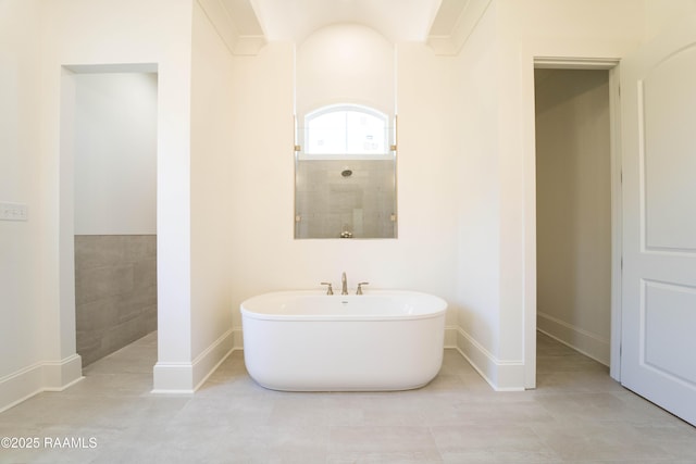 full bath with a freestanding tub, baseboards, tiled shower, and tile patterned floors