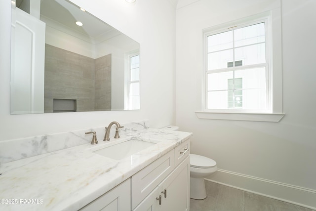 bathroom featuring toilet, baseboards, and vanity