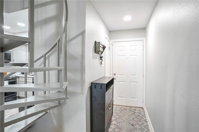 staircase with baseboards and a textured wall