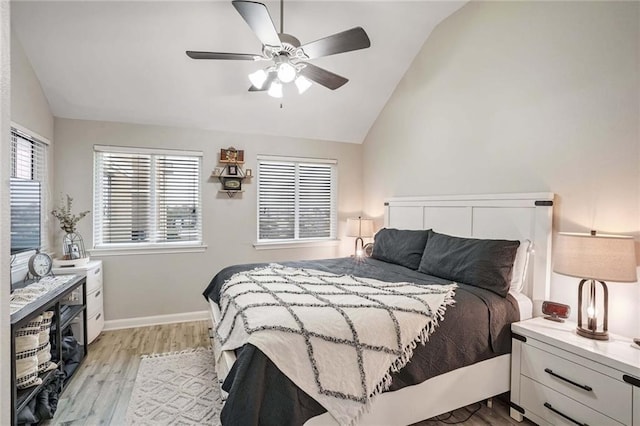 bedroom with vaulted ceiling, ceiling fan, light wood-type flooring, and baseboards