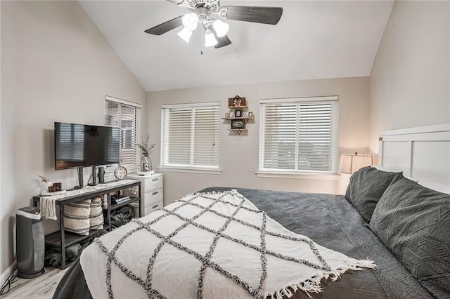 bedroom with lofted ceiling, a ceiling fan, and wood finished floors