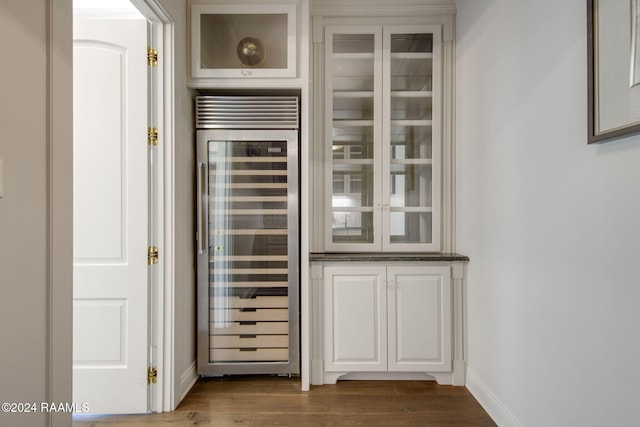 details featuring beverage cooler and hardwood / wood-style flooring