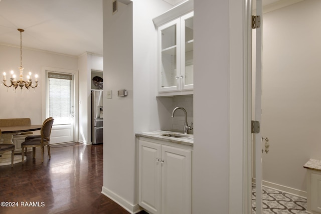 bar with light stone counters, dark wood-type flooring, sink, white cabinets, and stainless steel fridge with ice dispenser