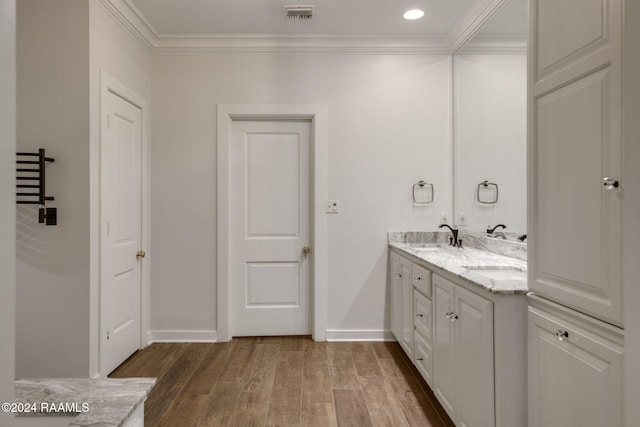 bathroom with vanity, ornamental molding, and hardwood / wood-style flooring