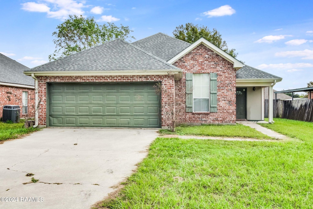 view of front of house with a garage, cooling unit, and a front yard