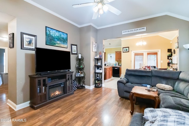 living room with ceiling fan with notable chandelier, light hardwood / wood-style floors, crown molding, and vaulted ceiling