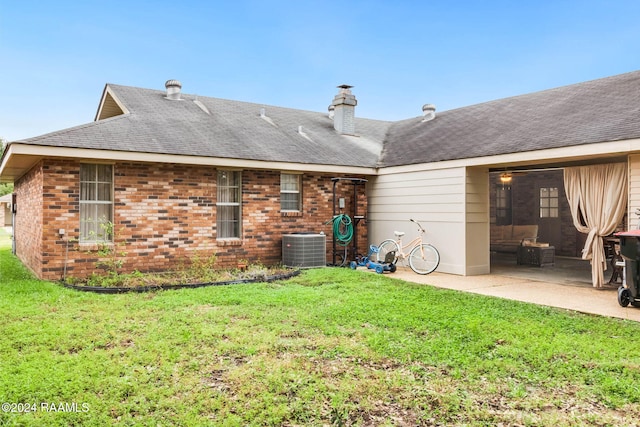 rear view of house with a yard, a patio, and central AC unit