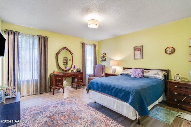 bedroom featuring a textured ceiling and light hardwood / wood-style floors