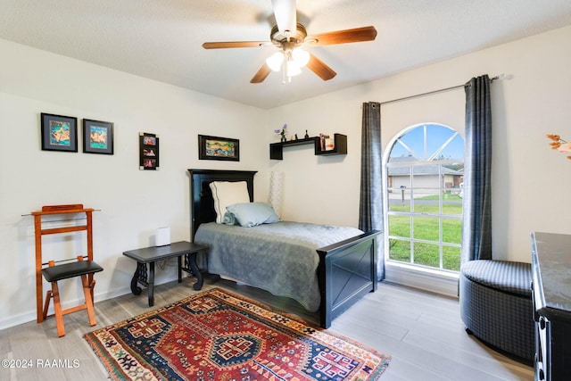 bedroom featuring a textured ceiling, light hardwood / wood-style flooring, and ceiling fan