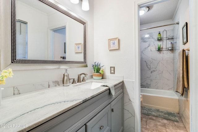 full bathroom with tile patterned floors, ornamental molding, vanity, tiled shower / bath combo, and toilet