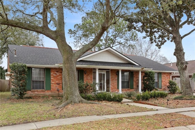 single story home featuring roof with shingles, fence, and brick siding