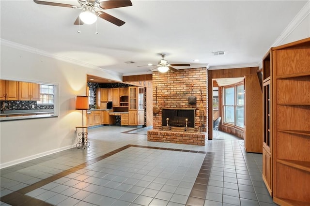 unfurnished living room featuring tile patterned flooring, a ceiling fan, visible vents, a brick fireplace, and crown molding