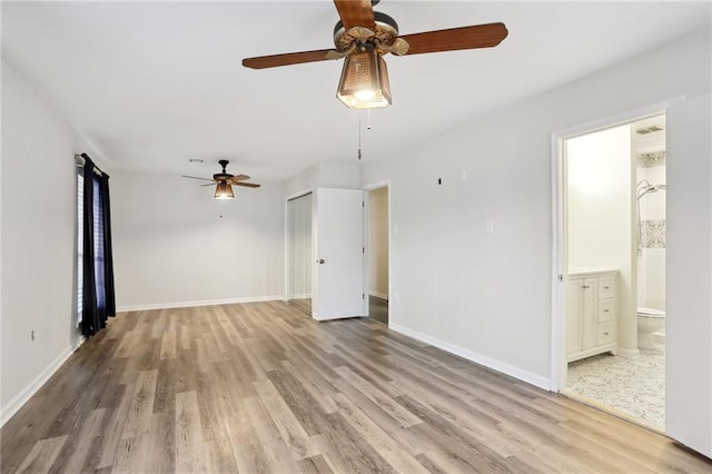 spare room featuring baseboards and light wood-style floors