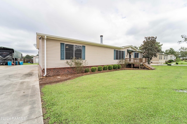 manufactured / mobile home featuring a garage, a deck, and a front yard